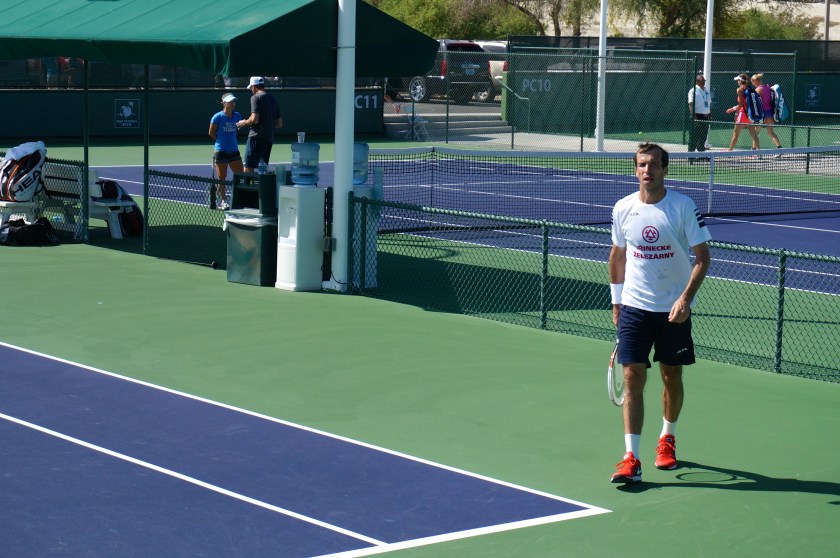 Stepanek in the foreground, coaching for an upcoming women's match going on in the background