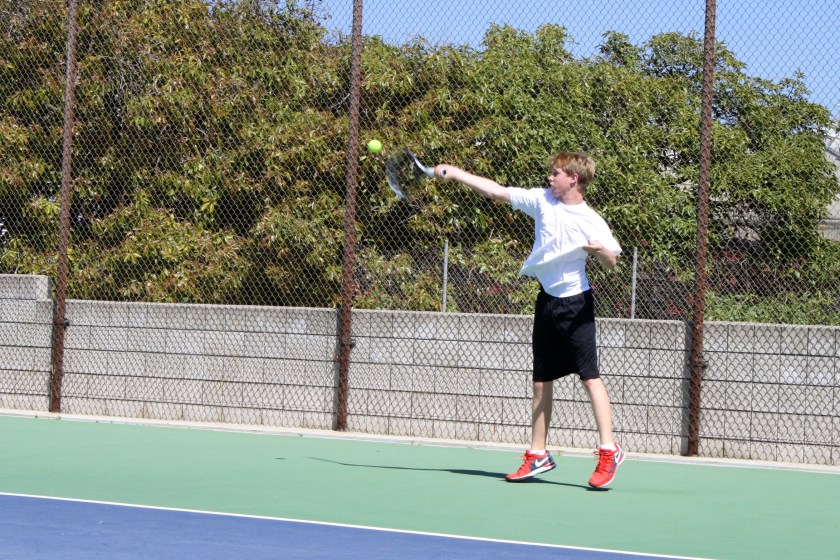 Kylan getting up for the high forehand.